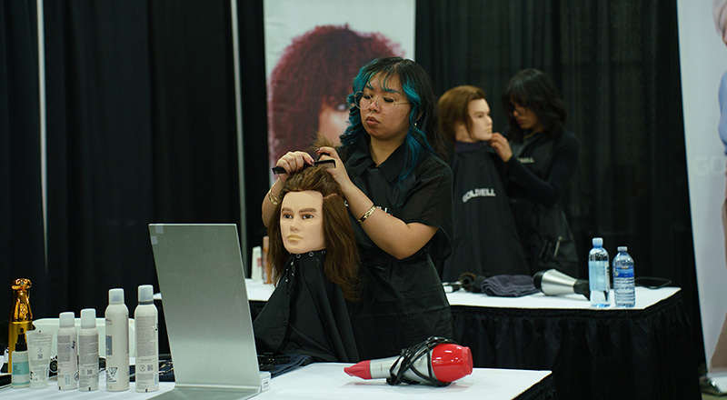 A hairstyling student cutting mannequin