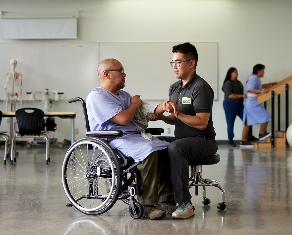 Occupational therapy student helping a patient in a wheelchair