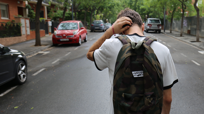 Student walking on street wearing backpack