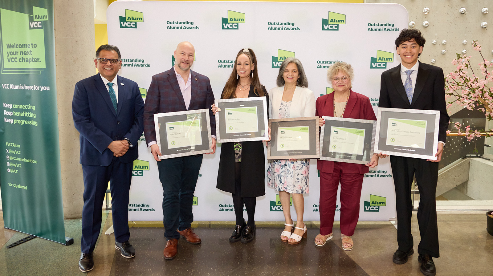 A group of alumni posing with the award certificates