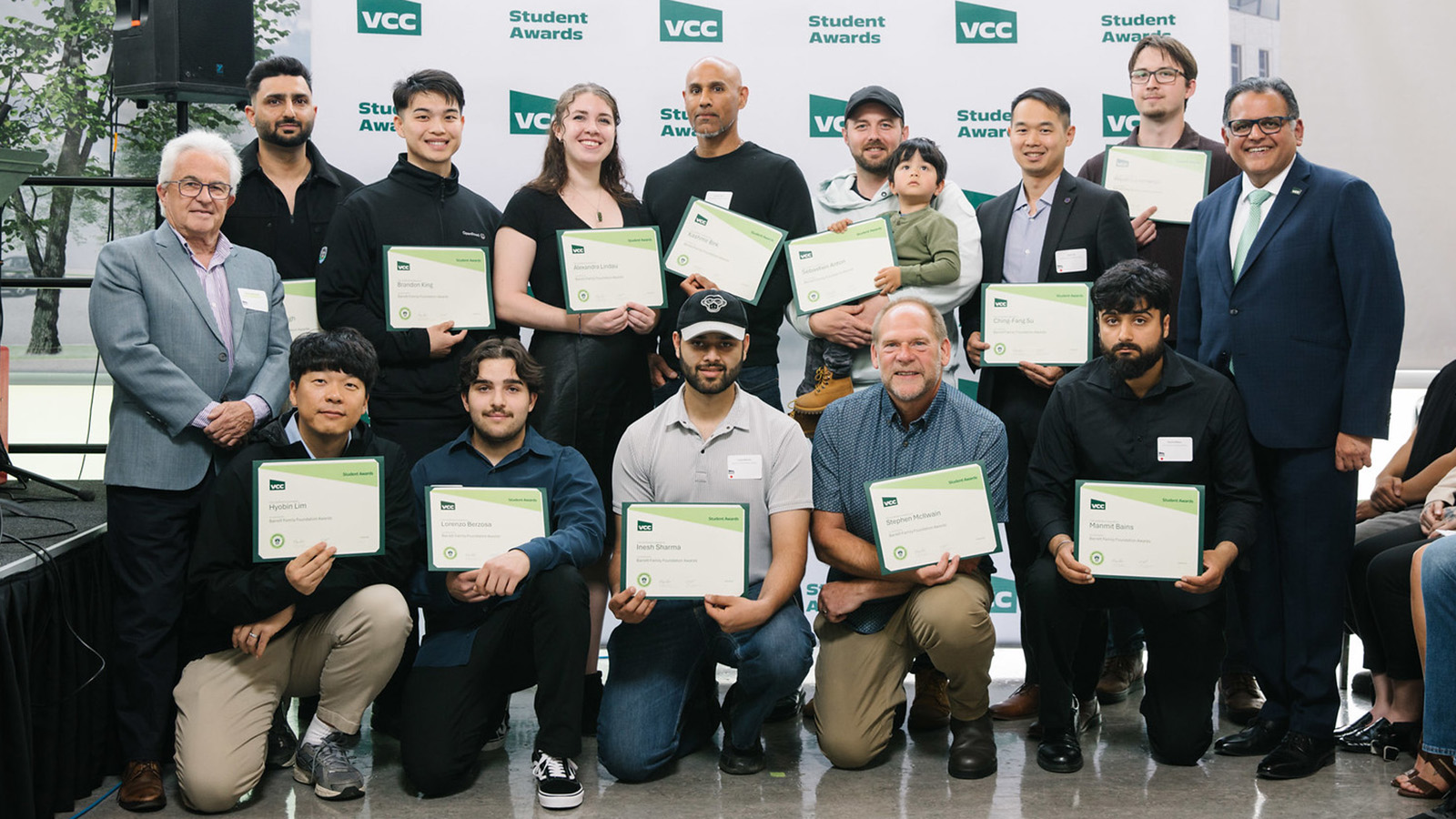 A group of students posting with their award certificates