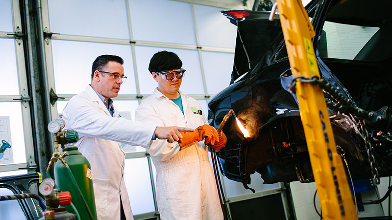 Automotive instructor teaches a student