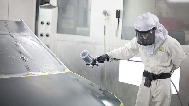 auto student learning spray gun technology to paint a car