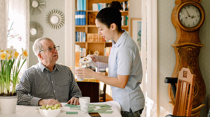 care assistant helping an elderly man
