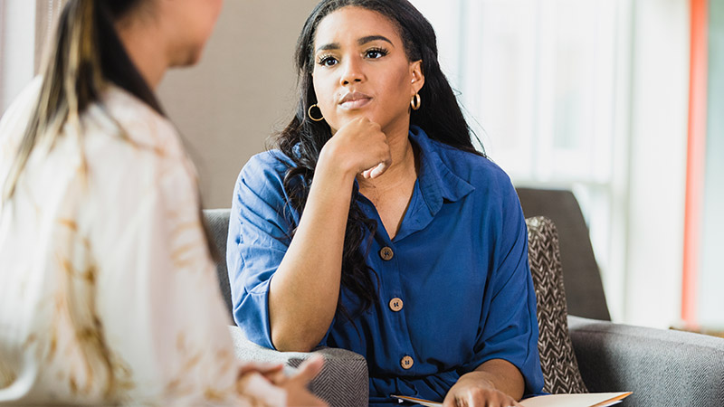 A female counsellor thoughtfully listens to a patient