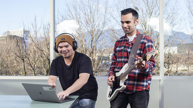 two musicians - a guitarist and a DJ with a laptop