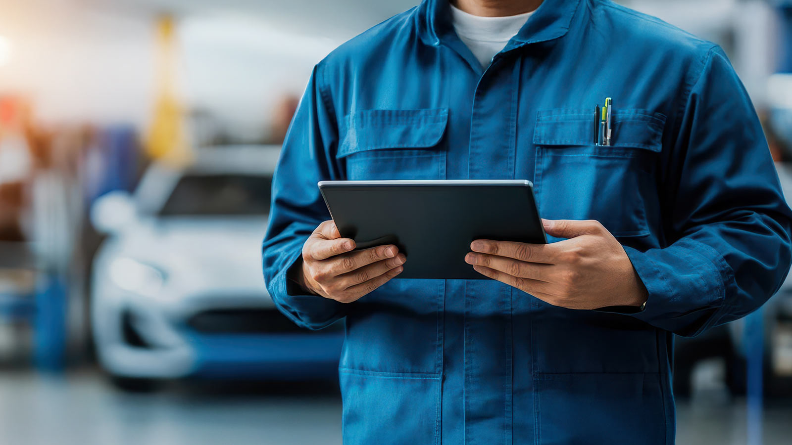 An automotive part serviceand advising collision student holding an ipad in a dealership setting