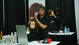 A hairstyling student cutting mannequin