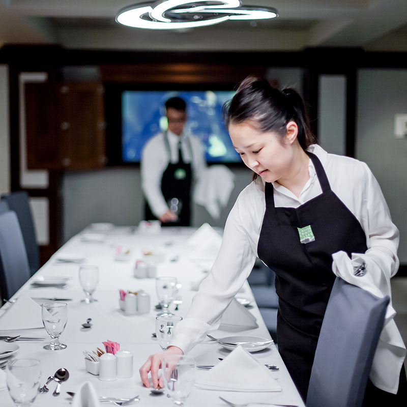hospitality student doing table set up at a restaurant