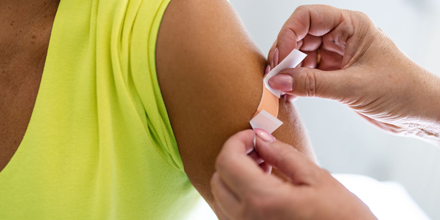 Doctor putting on a bandaid on to a patient