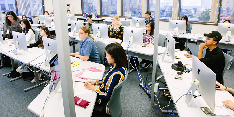 students is a calssroom using Mac desktop computers