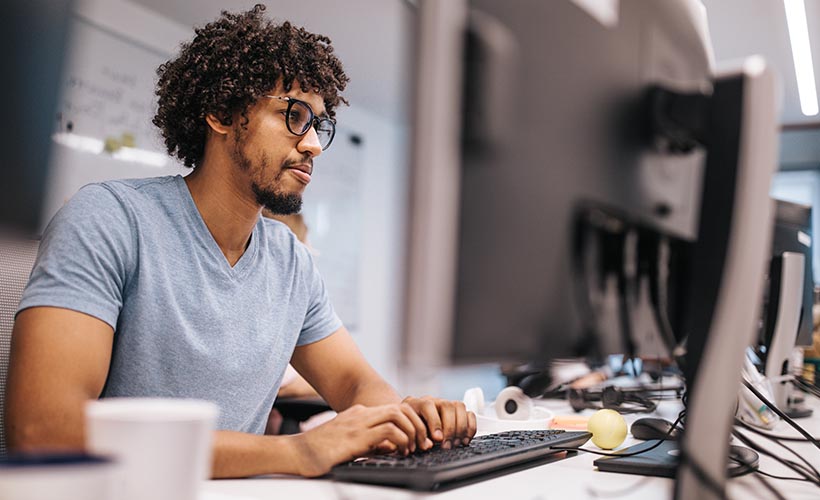 Male student in classroom, in front of a computer