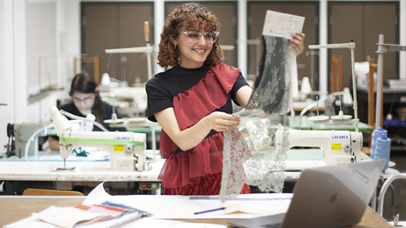 fashion student examines lace fabric